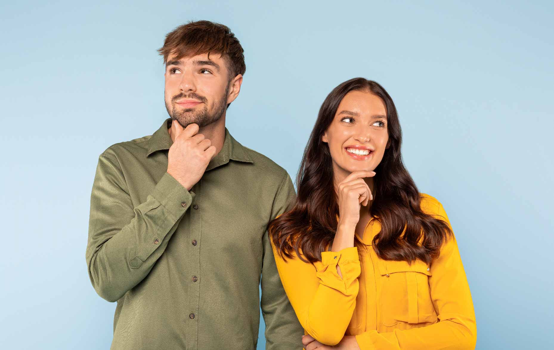 Man and women standing and holding their chin and smiling